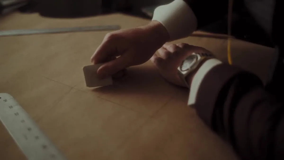 Ian drafting a bespoke pattern by hand at the cutting table