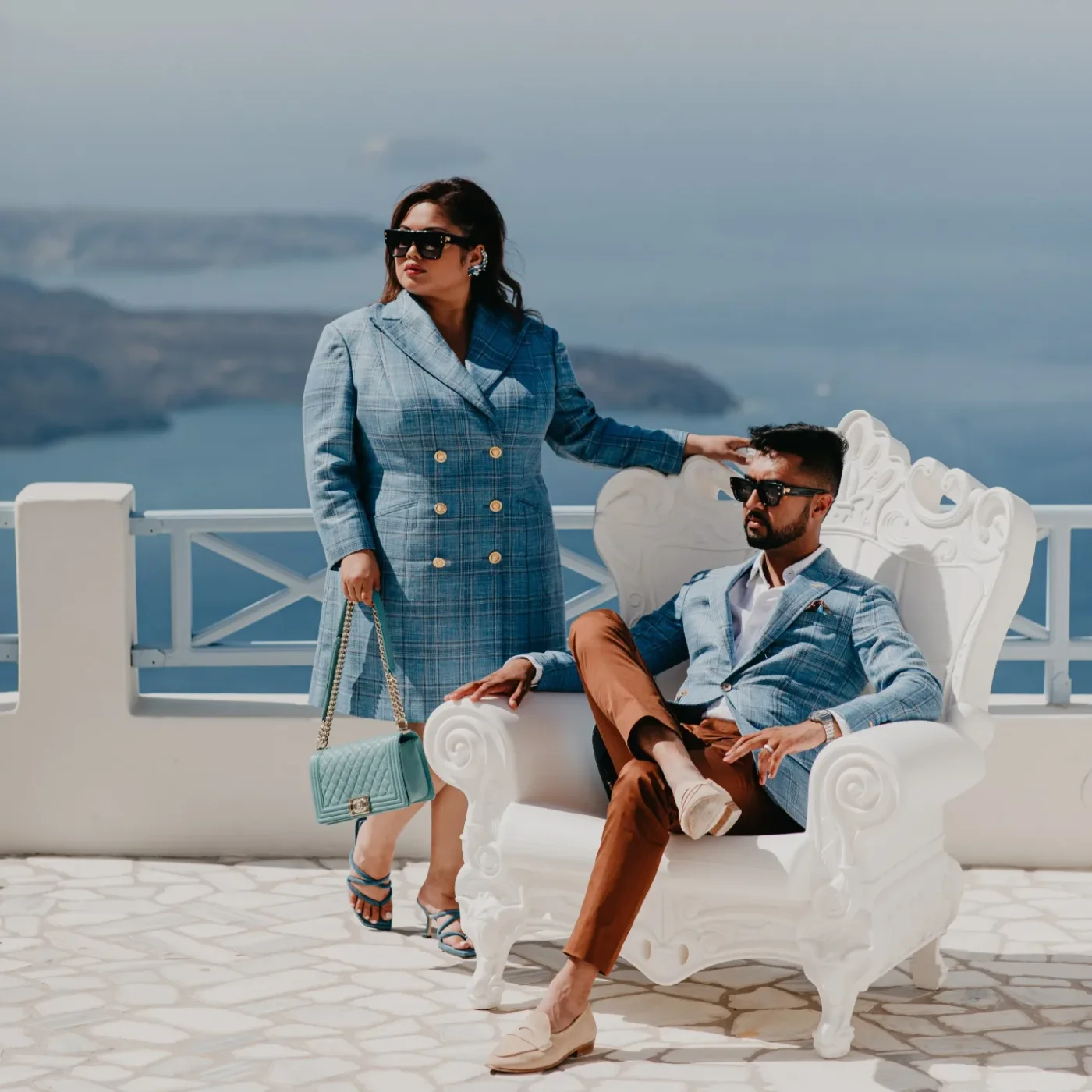 A couple in matching blue checked Loro Piana jackets for their pre-wedding photo shoot in Santorini