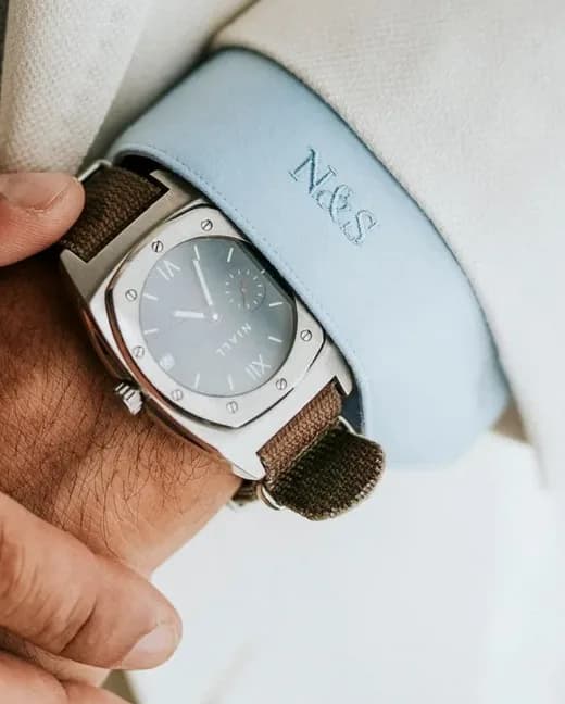 Embroidered monogram on a pale blue shirt cuff