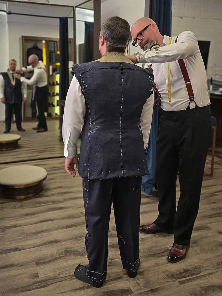 Ian refining a client's basted suit during a fitting at the Toronto atelier