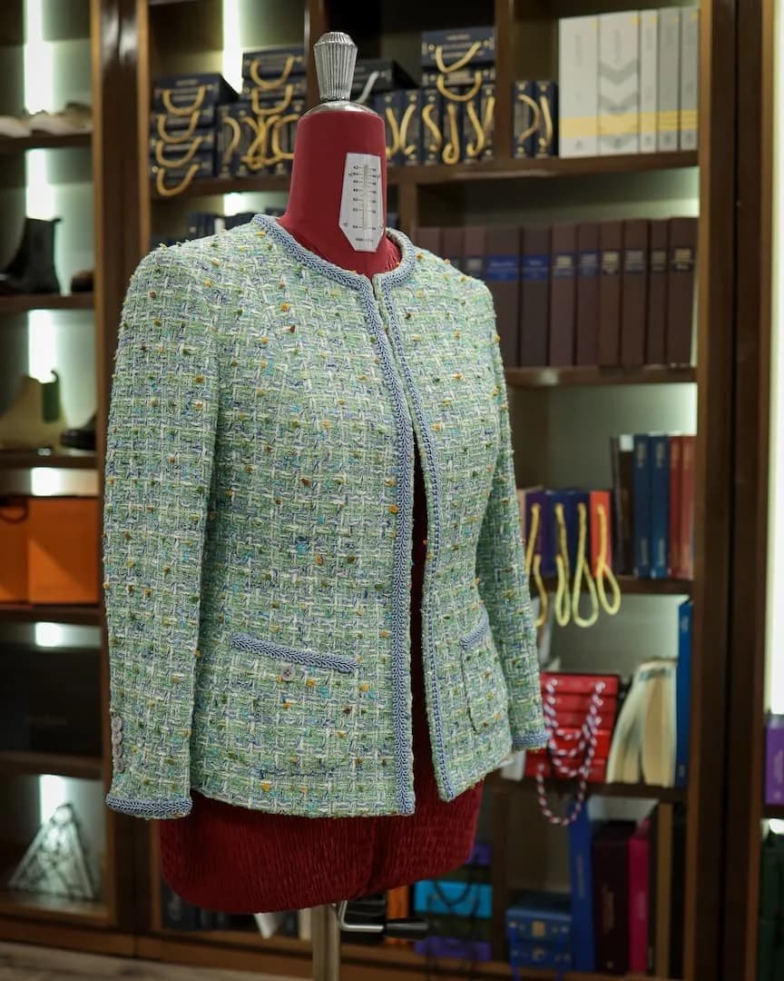 Soft green tweed women’s jacket with braided trim at the atelier