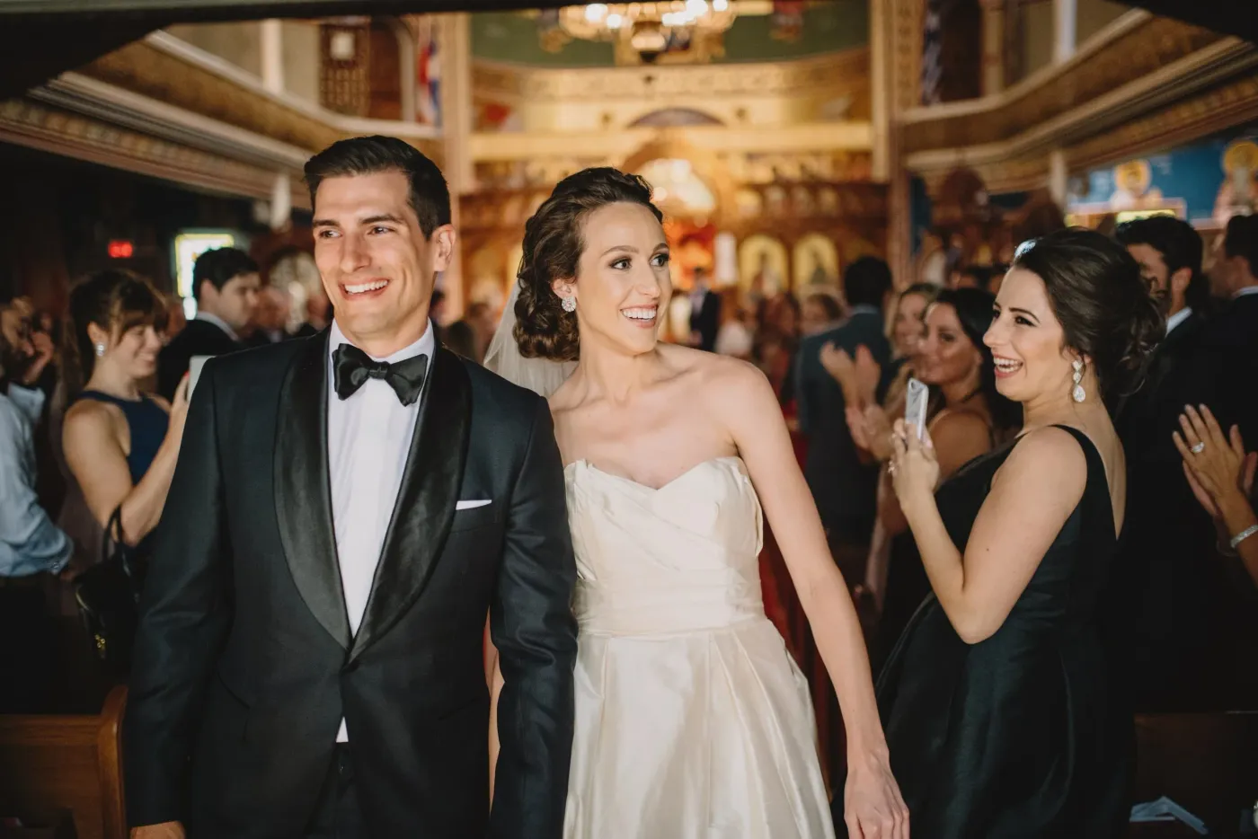 A newly married couple smiling and celebrating among their wedding guests
