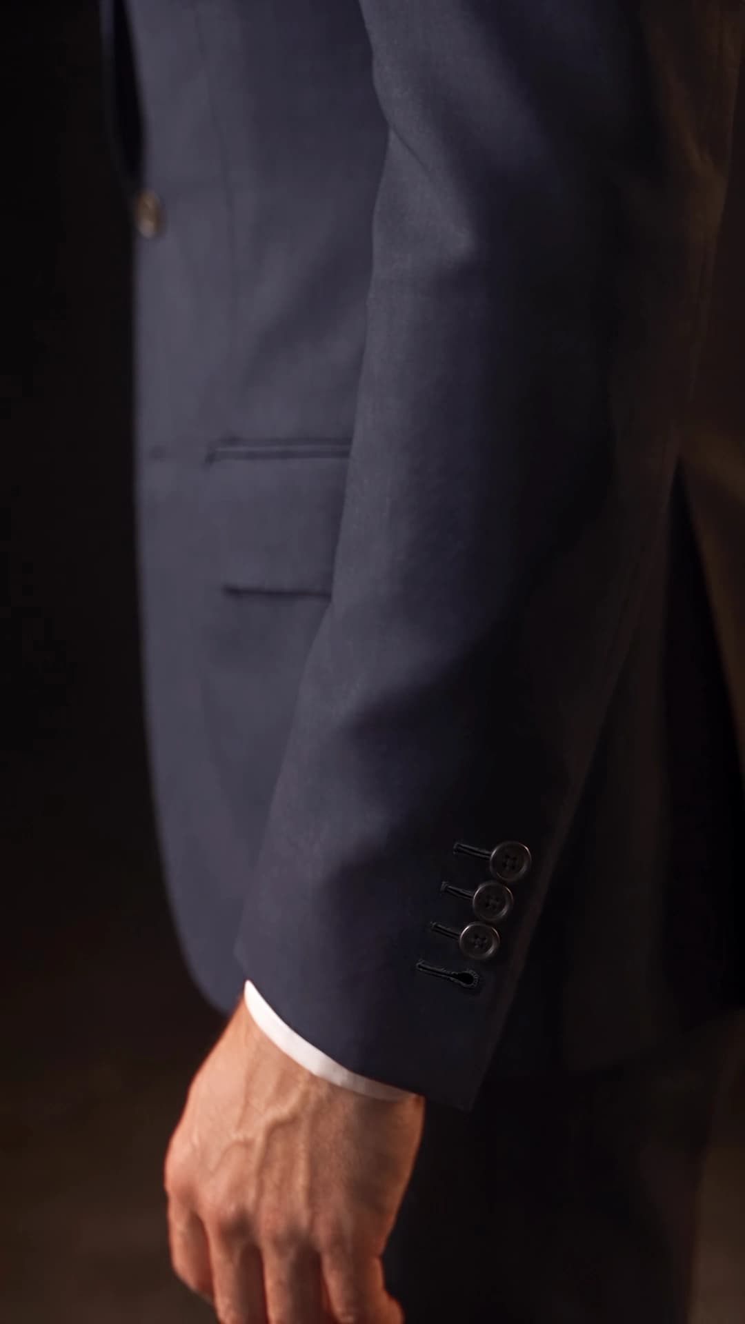Navy left sleeve with three fastened horn buttons and an unobstructed hand-finished buttonhole nearest the wrist