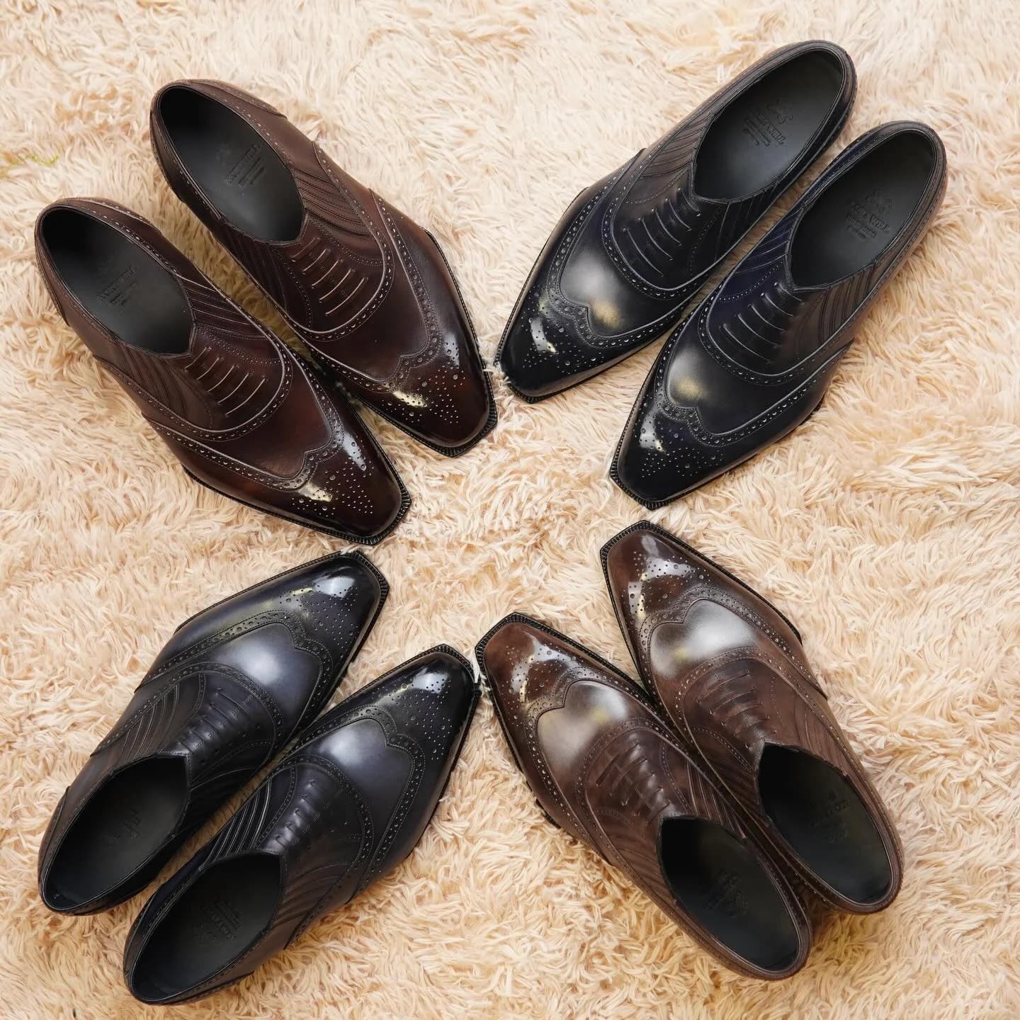 Four pairs of brown and black lazyman shoes arranged on a cream rug.