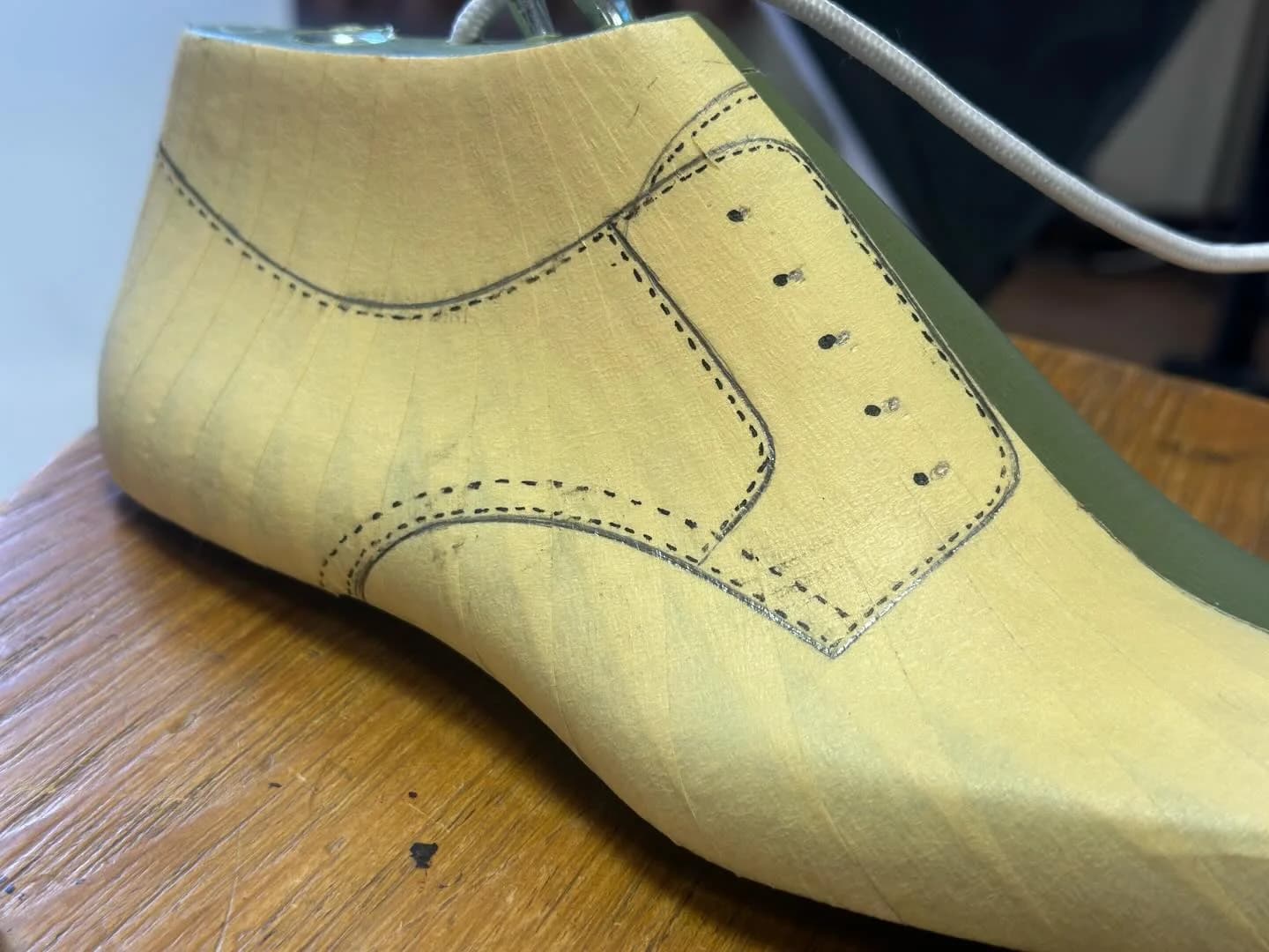Close view of the drawn seams and eyelet positions on the taped last.