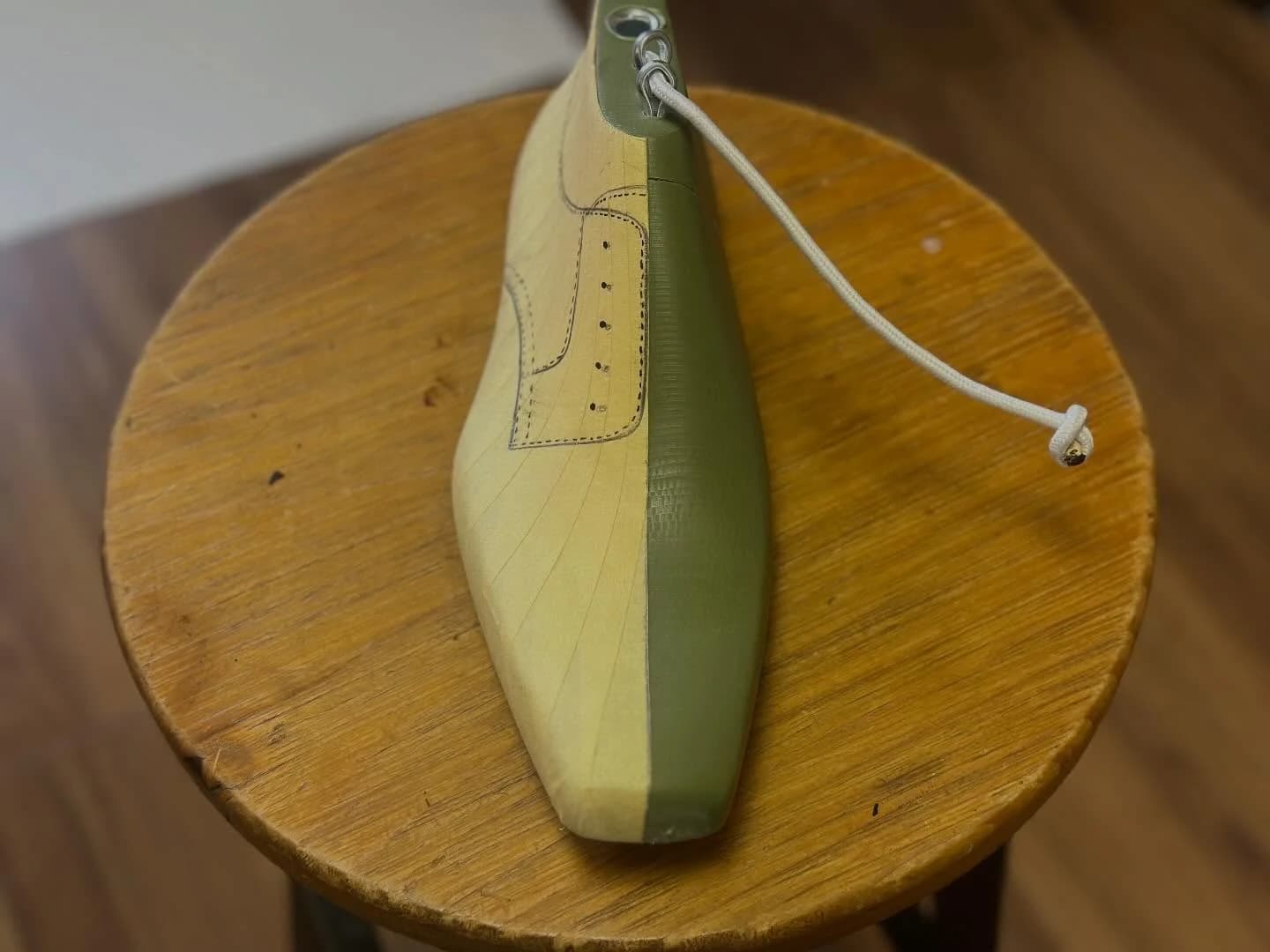 Front view of the last with one half taped and the shoe pattern drawn on it.
