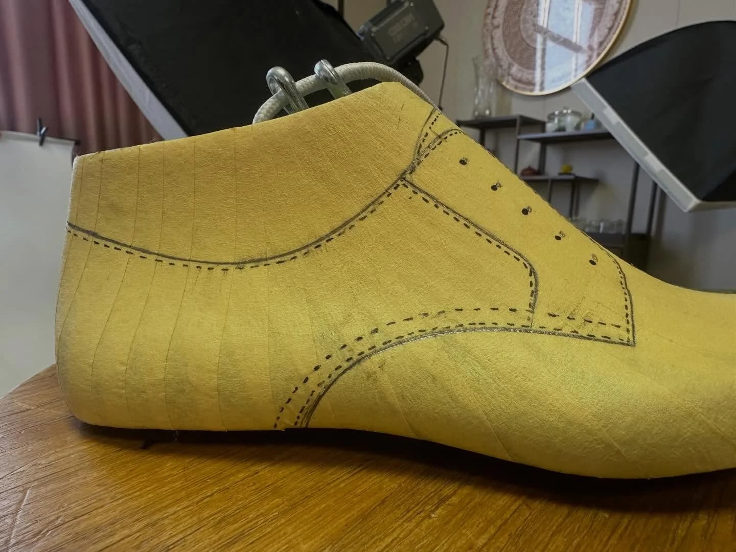 Side view of a taped shoe last with the upper pattern drawn onto it.