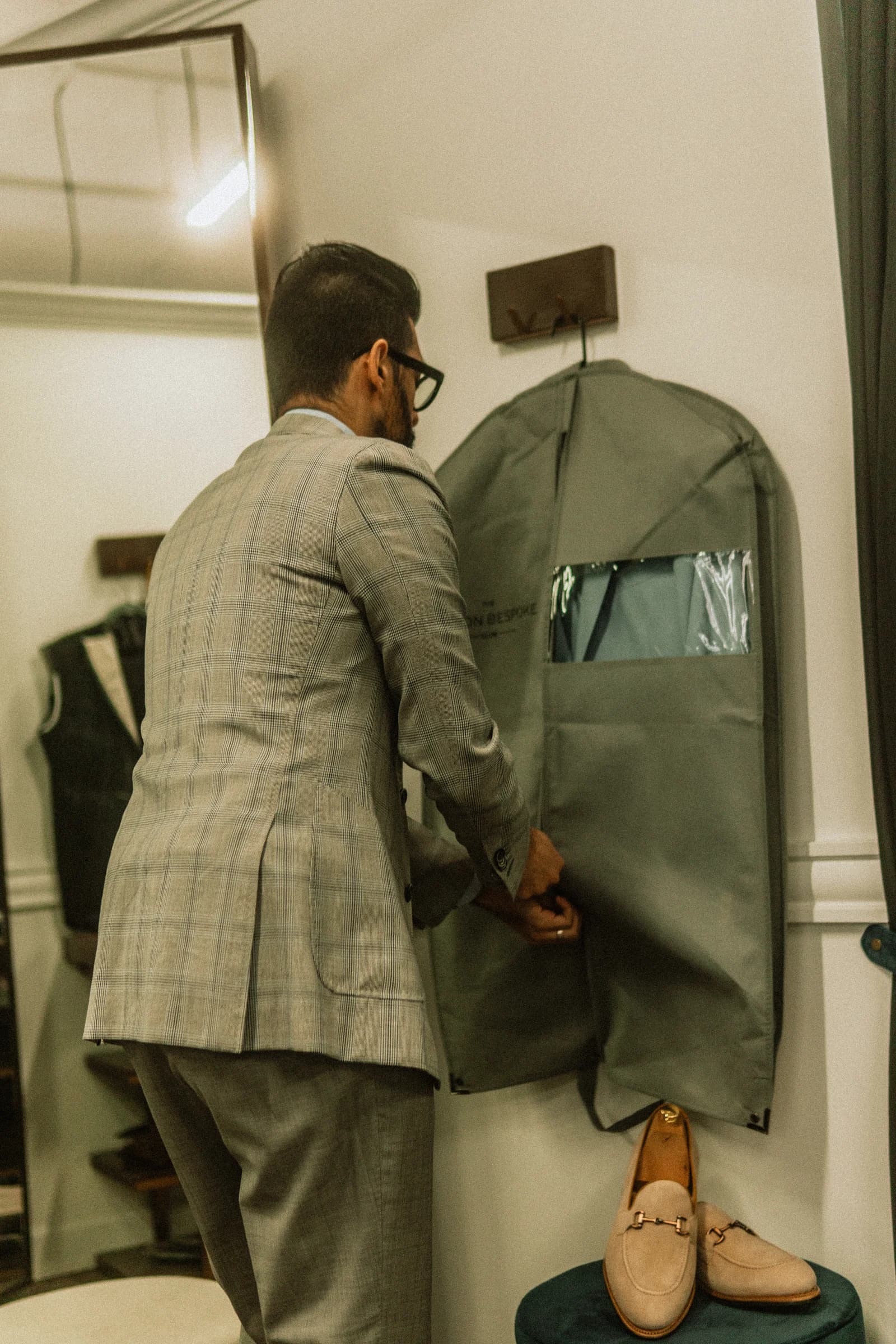 Kunal Arora closing a garment bag in preparation for delivery