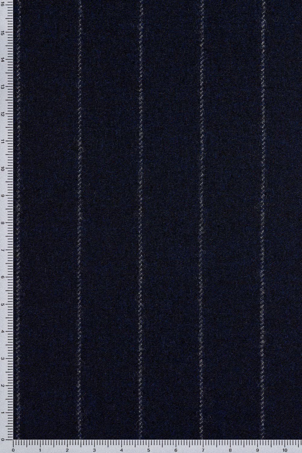 Navy cloth with pale vertical chalkstripes and rulers along the left and bottom edges