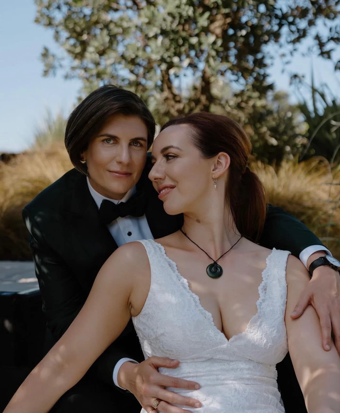 Kim in her forest green wedding tuxedo beside Melissa in her wedding dress