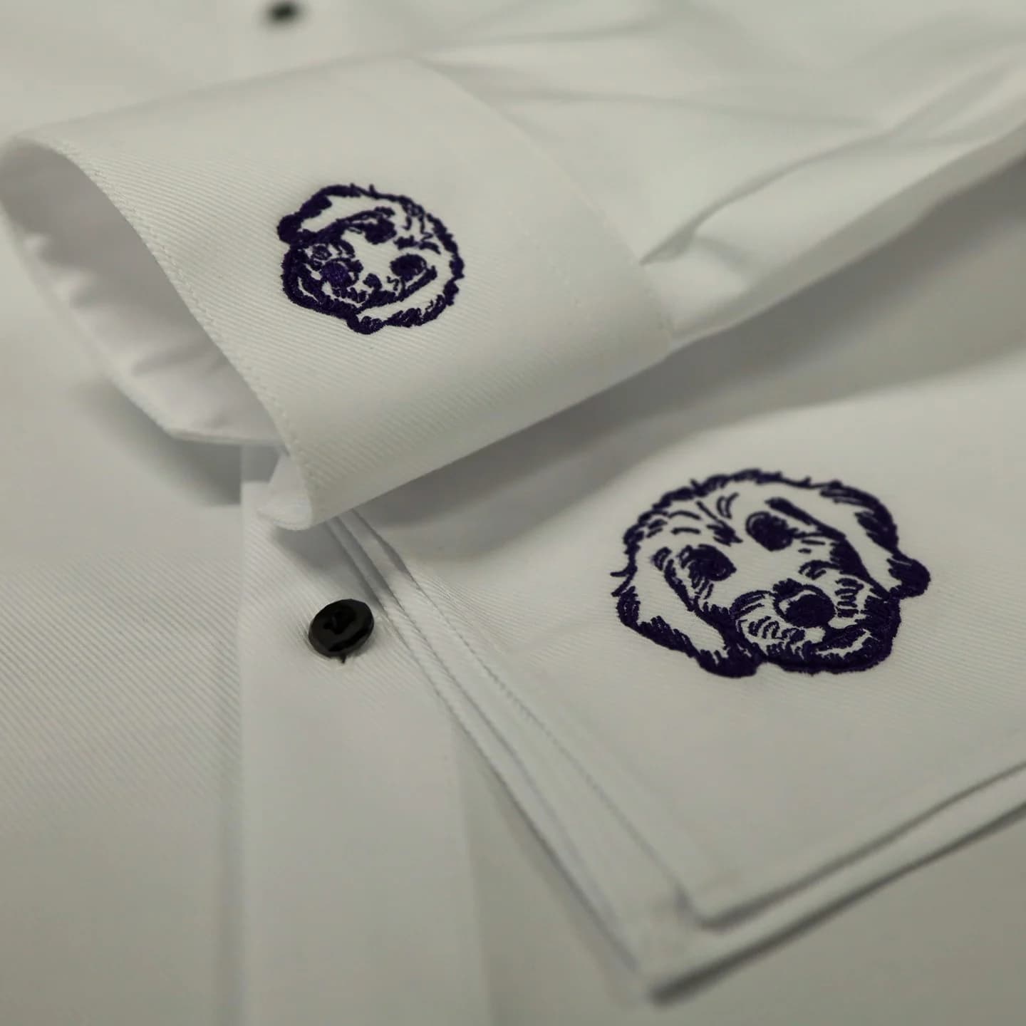 A client’s dog embroidered in dark thread on a white shirt sleeve and matching pocket square