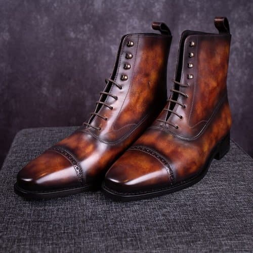 Brown lace-up boots with a hand-painted patina and darker toes and edges.